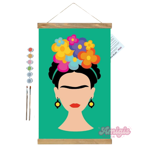 Framed artwork of a stylized portrait with colorful flowers on a green background, featuring the brand 'Amigie'.